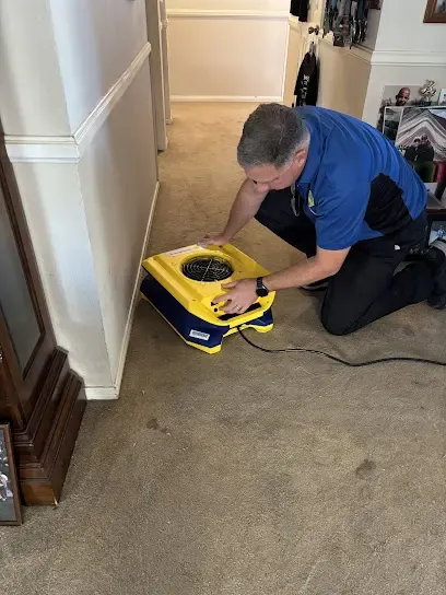 A technician extracting standing water from a flooded floor in a Santee, CA home